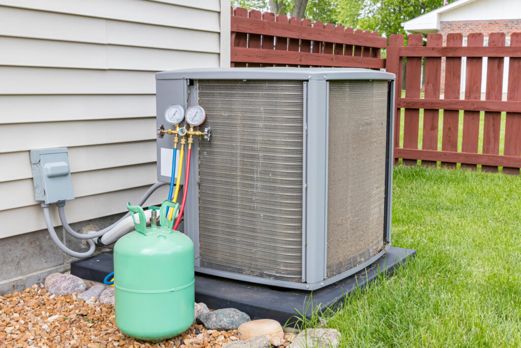A residential air conditioner getting an HVAC refrigerant refill also known as a recharge.